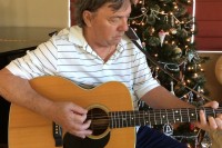 guitarist in front of Christymas tree playing Solitary Angel as Christmas gift