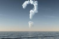 a question mark formed of clouds over the ocean and in a clear blue sky